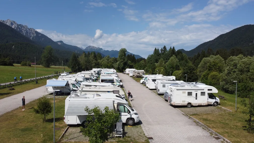 Camper in sosta nell'area Sosta e Relax di Fusine in Valromana, con le montagne sullo sfondo