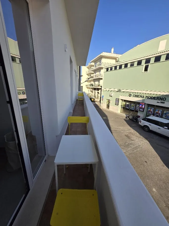 Il balcone con la sedia gialla, affacciato sulla via