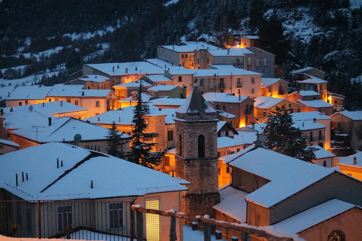 I tetti innevati di Carovilli all'imbrunire, con le prime luci accese