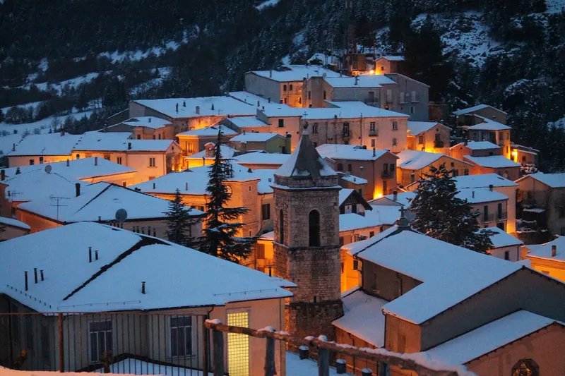 I tetti innevati di Carovilli all'imbrunire, con le prime luci accese